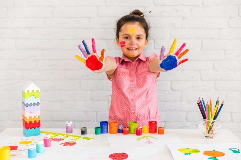 smiling portrait girl showing her painted colorful hand camera 2 Art & Creative Activities